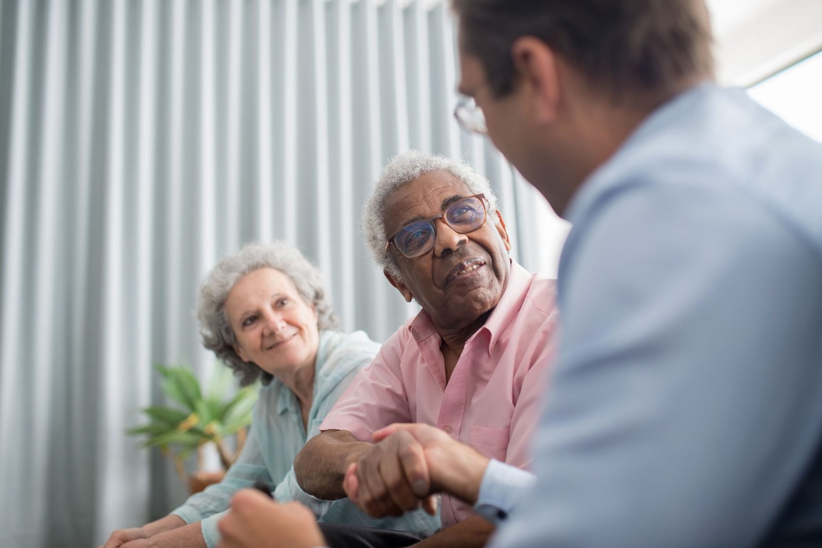 An adviser shaking hands with a client couple